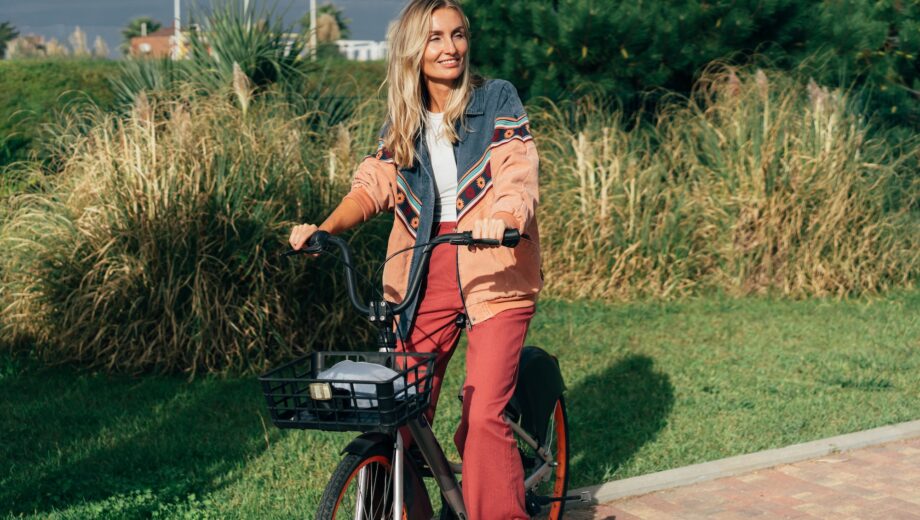 Young happy woman rides a rented electric bike.
